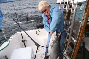 Marie Ellison struglles to hold up her prize catch of a 50lb Chinook